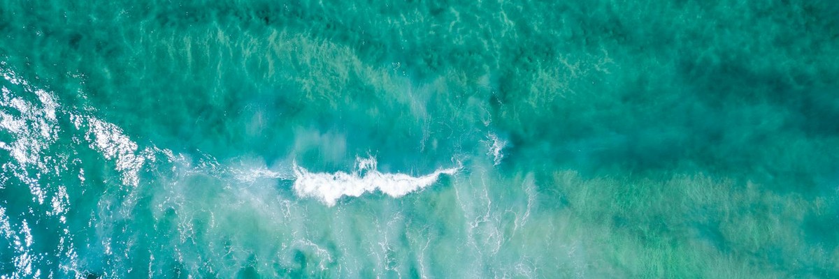 Stunning aerial view of turquoise ocean waves creating a vibrant, textured seascape.